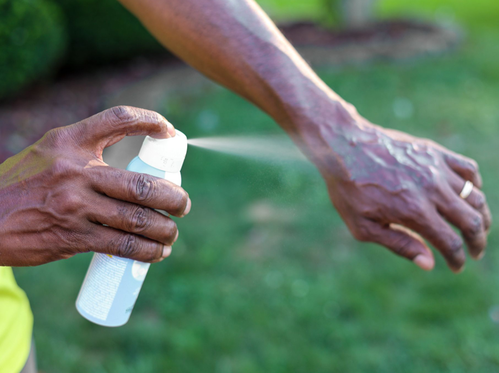 a man applying insect repellent to his hand.